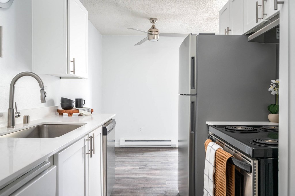 a kitchen with white cabinets and a stainless steel refrigerator
